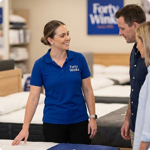 A Forty Winks sleep advisor helping customers choose a mattress in store
